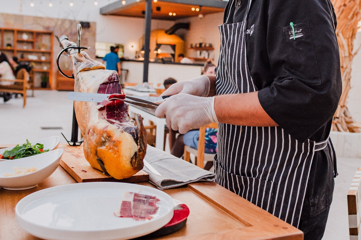 chef cutting iberico ham at noi restaurant in cabo